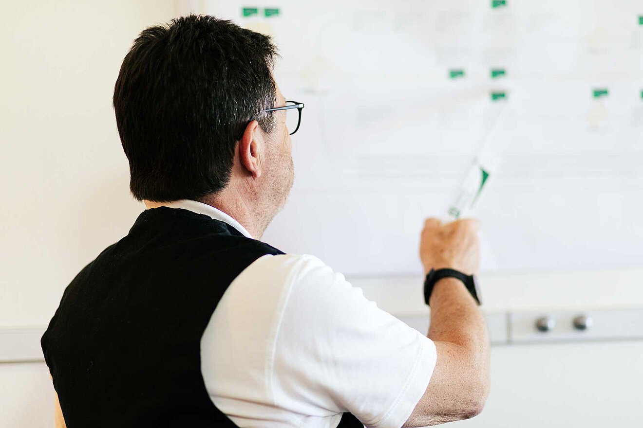 Besprechung und Projektplanung bei Aischtaler Holzhaus Georg Heinlein von Aischtaler Holzhaus präsentiert Bauplan am Whiteboard